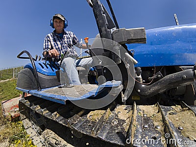 Driver on crawler tractor viewed from below Stock Photo