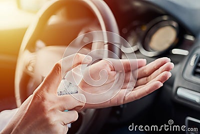 Driver disinfection hands with antibacterial sanitizer in the car before driving. Coronavirus preventative measure Stock Photo