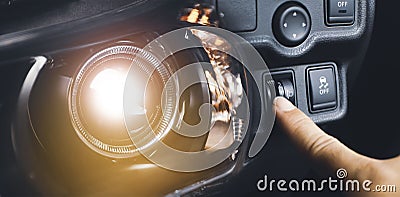 Driver hand adjusting headlight level switch and car headlight bright Stock Photo