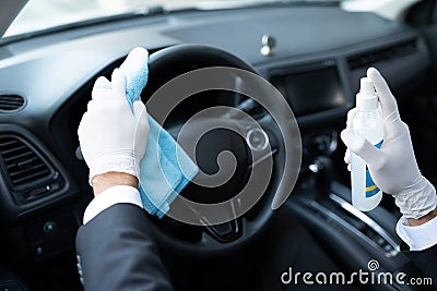 Driver Sanitizing Steering Wheel In Car Stock Photo