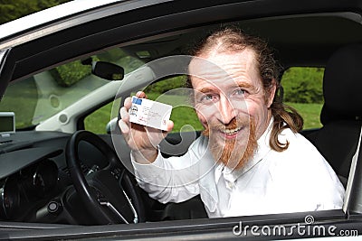 Driver smiling sitting in car with drivers license Stock Photo