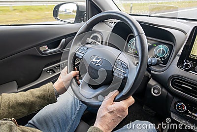 Driver at steering wheel while driving a car. Interior of Hyundai Kona hybrid Editorial Stock Photo