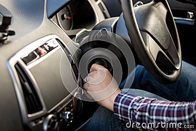 Driver turning ignition key in right-hand drive car Stock Photo
