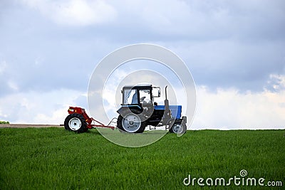 Driver wheeled tractor fertilizing winter wheat with mineral fertilizers Editorial Stock Photo