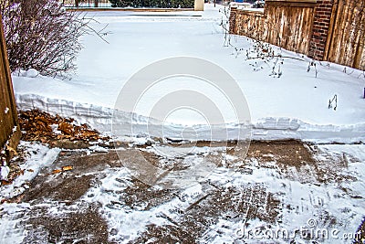 Driveway half shoveled of heavy snow with edge showing how deep it is Stock Photo