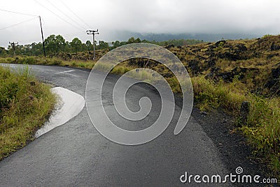 Driving across the caldera ridge road among view of extinct crater of the volcano Batur Stock Photo