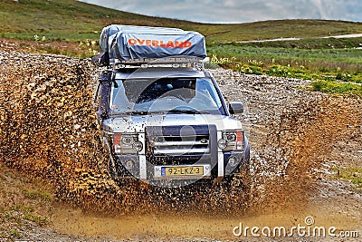 Driving through big mud puddle with Land Rover car..20/08/2010 - Val d`Isere, France Editorial Stock Photo