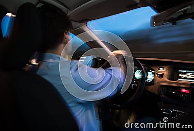 Young man driving his modern car at night in a city Stock Photo
