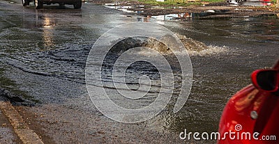 Driving cars on a flooded road during floods caused by rain storms. Cars float on water, flooding streets. Splash on the machine. Editorial Stock Photo