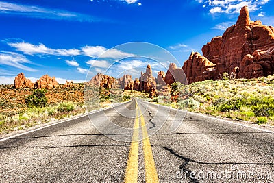 Driving through the-Desert with Monument Rock along the Road During Sunny Day, Arches NP Stock Photo