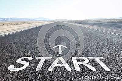 Driving on an empty road towards blue sky with sign start on asphalt Stock Photo