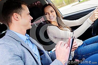 Driving instructor and woman student in examination car Stock Photo