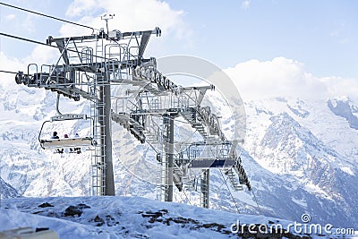 The driving mechanism of the lift high in the mountains on a clear day against the background of a blue sky. Winter sports and Stock Photo