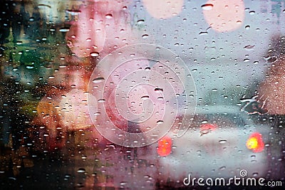 Driving in rain, raindrops on car window with light bokeh. Stock Photo