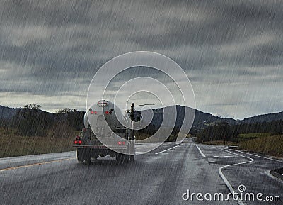 Driving in rain. Rainy road with liquid truck. Stock Photo