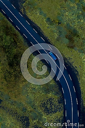 Driving on a road through the green mossy river water in Iceland, aerial, vertical Stock Photo