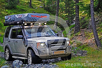 Driving through small stream of water on a off road forest trail with Land Rover with roof tents..20/08/2010 - Val d`Isere, Editorial Stock Photo