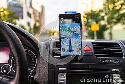 Driving and using waze maps application on smartphone on car dashboard, Driver using Waze maps app in Bucharest, Romania, 2021 Editorial Stock Photo