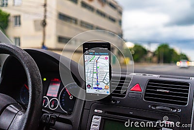 Driving and using waze maps application on smartphone on car dashboard, Driver using Waze maps app in Bucharest, Romania, 2021 Editorial Stock Photo
