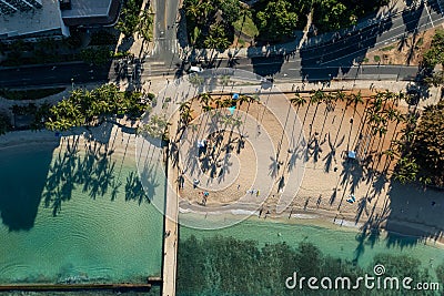 Drone, aerial shot of Waikiki beach with palm trees shadows in the morning sun Stock Photo