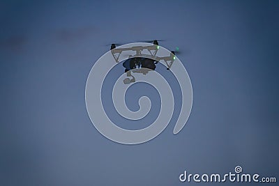 Drone with a camera flying in night sky. Spying with quadcopter Stock Photo