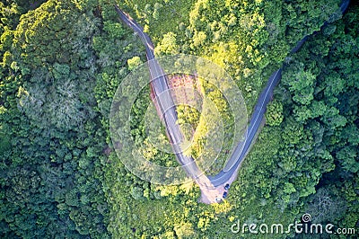 Drone field of view of winding road forming patterns in nature against background of forest and trees on secluded island of Mahe, Stock Photo