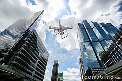 Drone with high resolution digital camera flying over city . An aerial view of a flying multi-copter with raised landing gears and Stock Photo