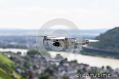 The drone hovers over the grape hills and countryside, the plastic propellers are on and the camera on the gimbal is visible. Stock Photo