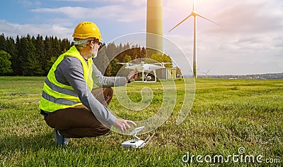 Drone operated by construction worker inspecting wind turbine Stock Photo