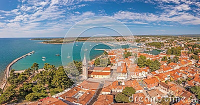 Drone panorama over the roofs of the Croatian coastal town of Novigrad with harbor and church during daytime Stock Photo
