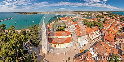 Drone panorama over the roofs of the Croatian coastal town of Novigrad with harbor and church during daytime Stock Photo