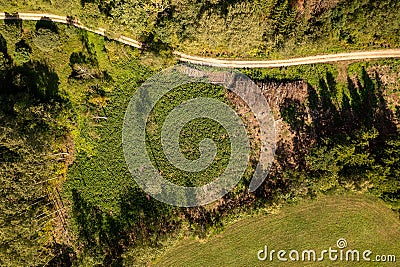 Drone photography of a pile of logs near a rural dirt road and logging site Stock Photo