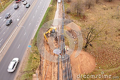 Drone photography of sewage pipe being lade down i a ditch by a road during autumn day Stock Photo