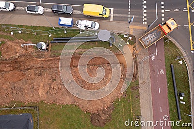 Drone photography of sewage pipe being lade down i a ditch by a road during autumn day Stock Photo