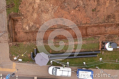 Drone photography of sewage pipe being lade down i a ditch by a road during autumn day Stock Photo