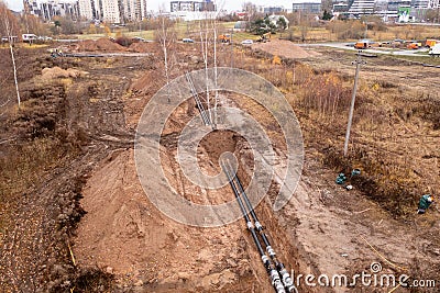 Drone photography of sewage pipe being lade down i a ditch by a road during autumn day Stock Photo