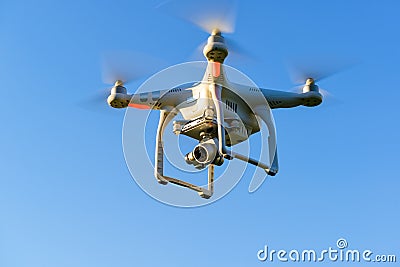 Drone quad copter with digital camera flying in blue sky Stock Photo