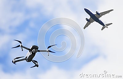 Drone quadcopter flying and airplane aircraft in sky in danger of crash or collision Stock Photo