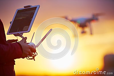 Drone quadcopter flying at sunset Stock Photo