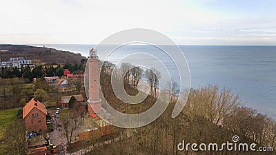 A drone captures Gaski beach, West Pomeranian Voivodeship, Poland, featuring a red brick lighthouse, Baltic Sea, sandy shore, Stock Photo