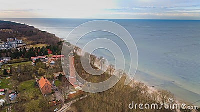 A drone captures Gaski beach, West Pomeranian Voivodeship, Poland, featuring a red brick lighthouse, Baltic Sea, sandy shore, Stock Photo