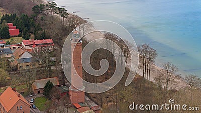 A drone captures Gaski beach, West Pomeranian Voivodeship, Poland, featuring a red brick lighthouse, Baltic Sea, sandy shore, Stock Photo