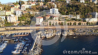 Drone shot of the rocky coast of the Bordighera, Italy with boats on its harbor Stock Photo