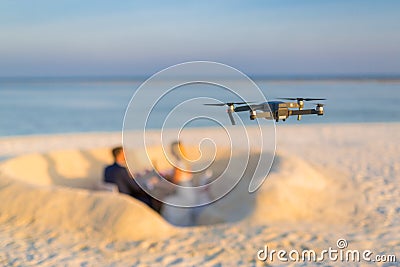 Drone taking footage and images of wedding couple at the beach Stock Photo