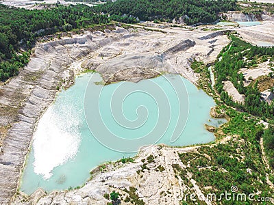 Drone view on a flooded kaolin quarry with turquoise water and white shore. Aerial shot of a kaolin pit flooded with water Stock Photo