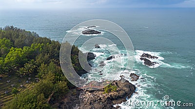 Drone view of Menganti Beach, Kebumen, Indonesia, beautiful beach with white sand, calm waves, coral cliffs and green trees Stock Photo