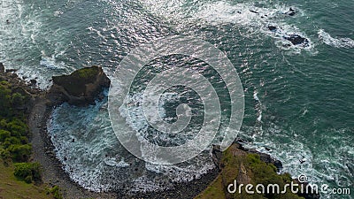 Drone view of Menganti Beach, Kebumen, Indonesia, beautiful beach with white sand, calm waves, coral cliffs and green trees Stock Photo