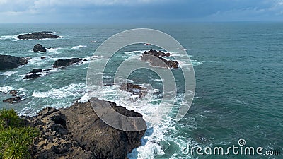 Drone view of Menganti Beach, Kebumen, Indonesia, beautiful beach with white sand, calm waves, coral cliffs and green trees Stock Photo
