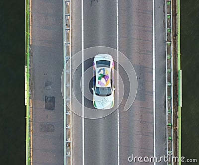 Drone view of a painted white Bentley Unifying spur car driving on a bridge Editorial Stock Photo