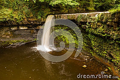 Aerial view of a picturesque waterfall and pool in a narrow canyon and green forest Sgwd Gwladys, Brecon Beacons, Wales Stock Photo